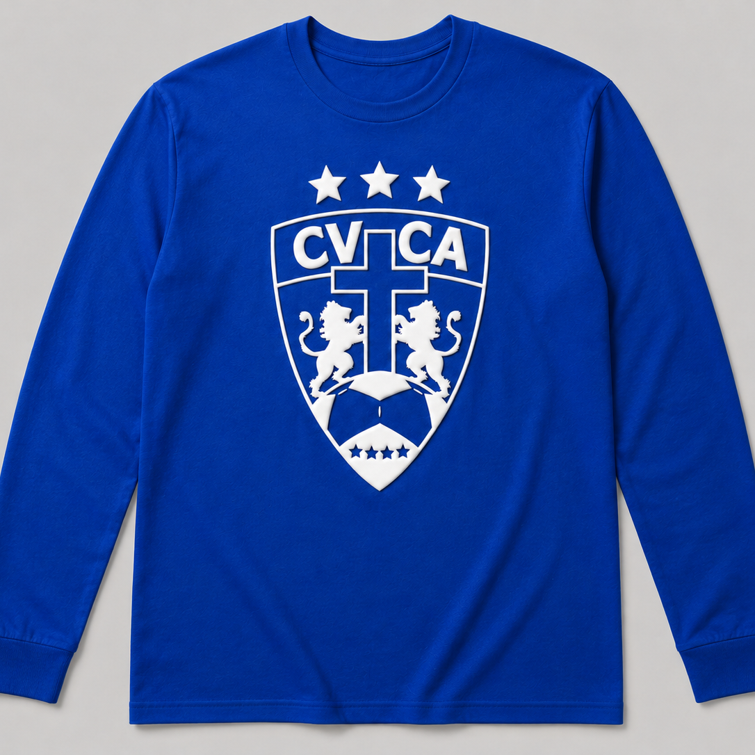 A royal blue long-sleeve t-shirt with a white printed CVCA shield crest on the chest, displayed against a neutral gray background.