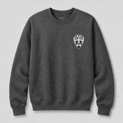 A dark heather gray crewneck sweatshirt with a white and black shield crest on the left chest, featuring the brand name 'DISTRICT' printed inside the collar, shown against a light gray background.